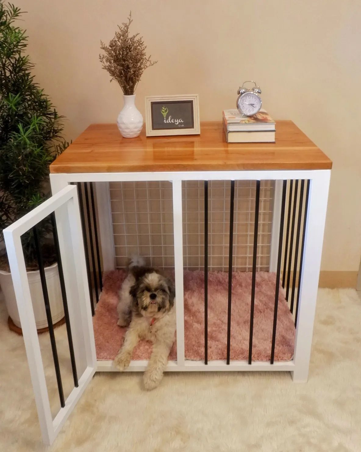 Small dog inside a white crate with a wooden table topper on top.