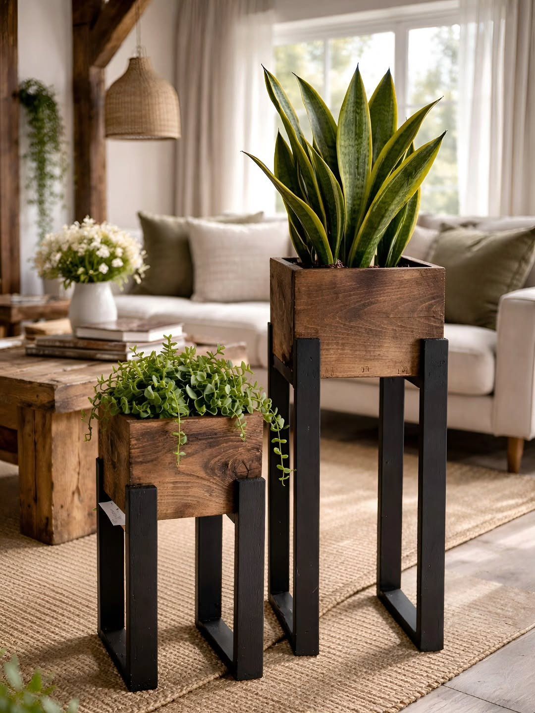 Two nesting wooden plant stands with black metal legs in a living room.