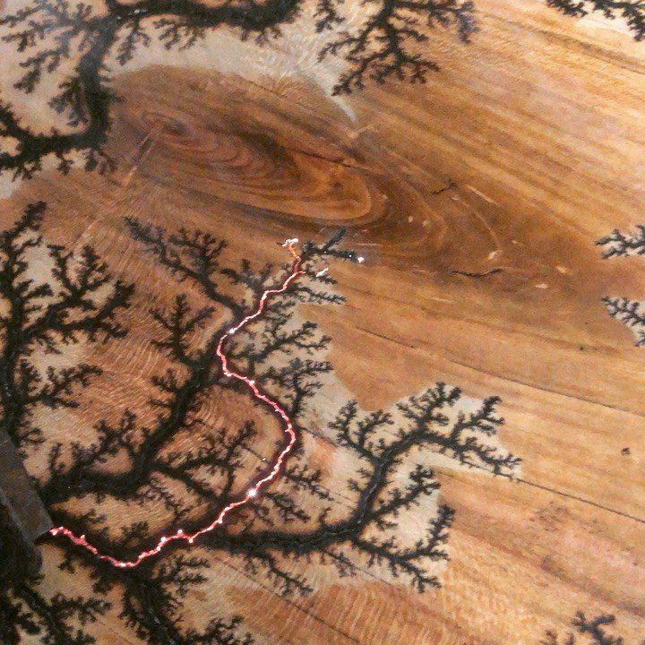 What Can You Do With Burned and Stained Wood? 5 Ideas 5 Wooden surface with black fractal burned patterns and a glowing red line.