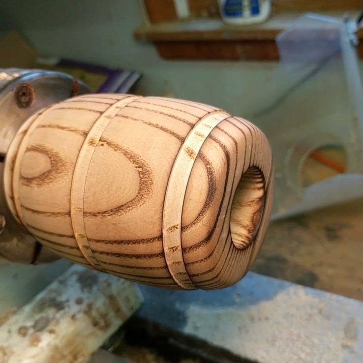 Burned Wood Finish Ideas: 8 Charred Projects for Home 8 Wooden cylindrical object on a lathe with dark burned wood finish patterns.