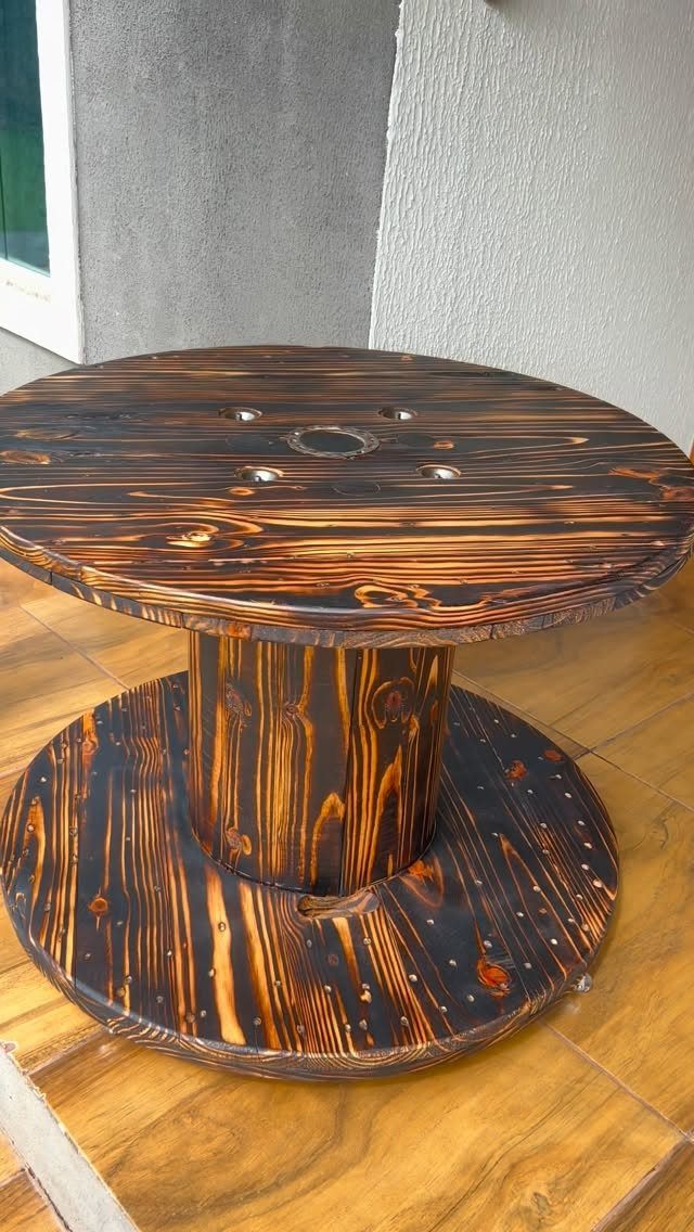 Burned Wood Finish Ideas: 8 Charred Projects for Home 2 Charred wooden cable spool table with a glossy, sealed blackened wood finish.