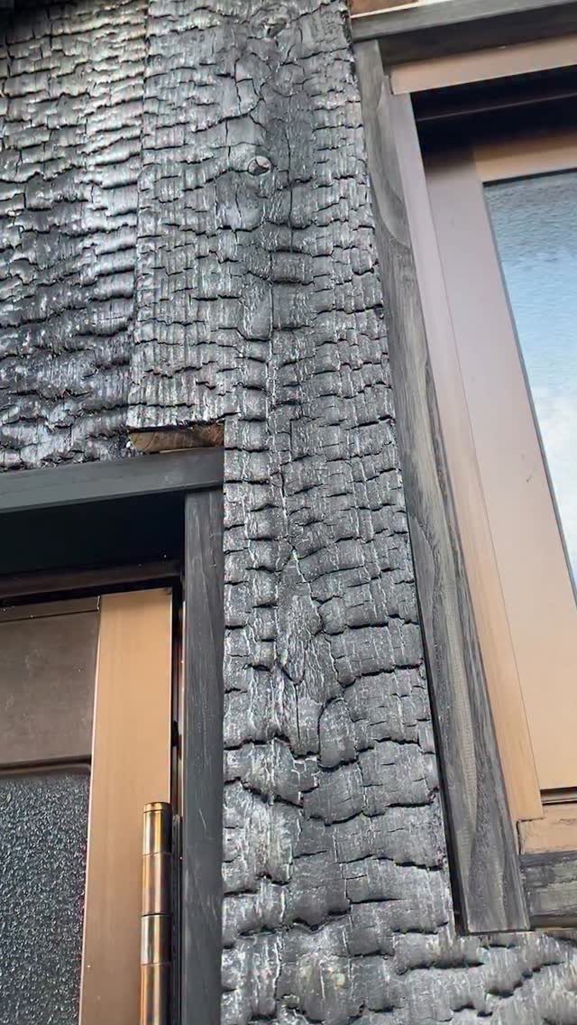 Burned Wood Finish Ideas: 8 Charred Projects for Home 6 Charred black wood siding with a scaly texture on a building exterior.