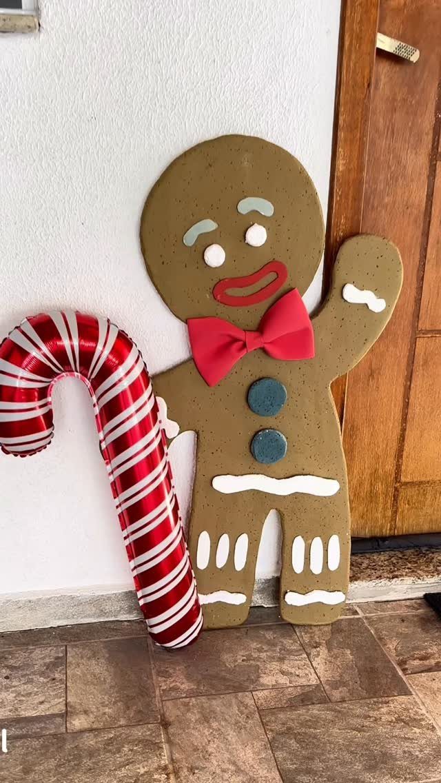 12 Christmas Decorations DIY for Outdoor Spaces 12 Gingerbread man cutout with red bow tie and candy cane balloon by a door