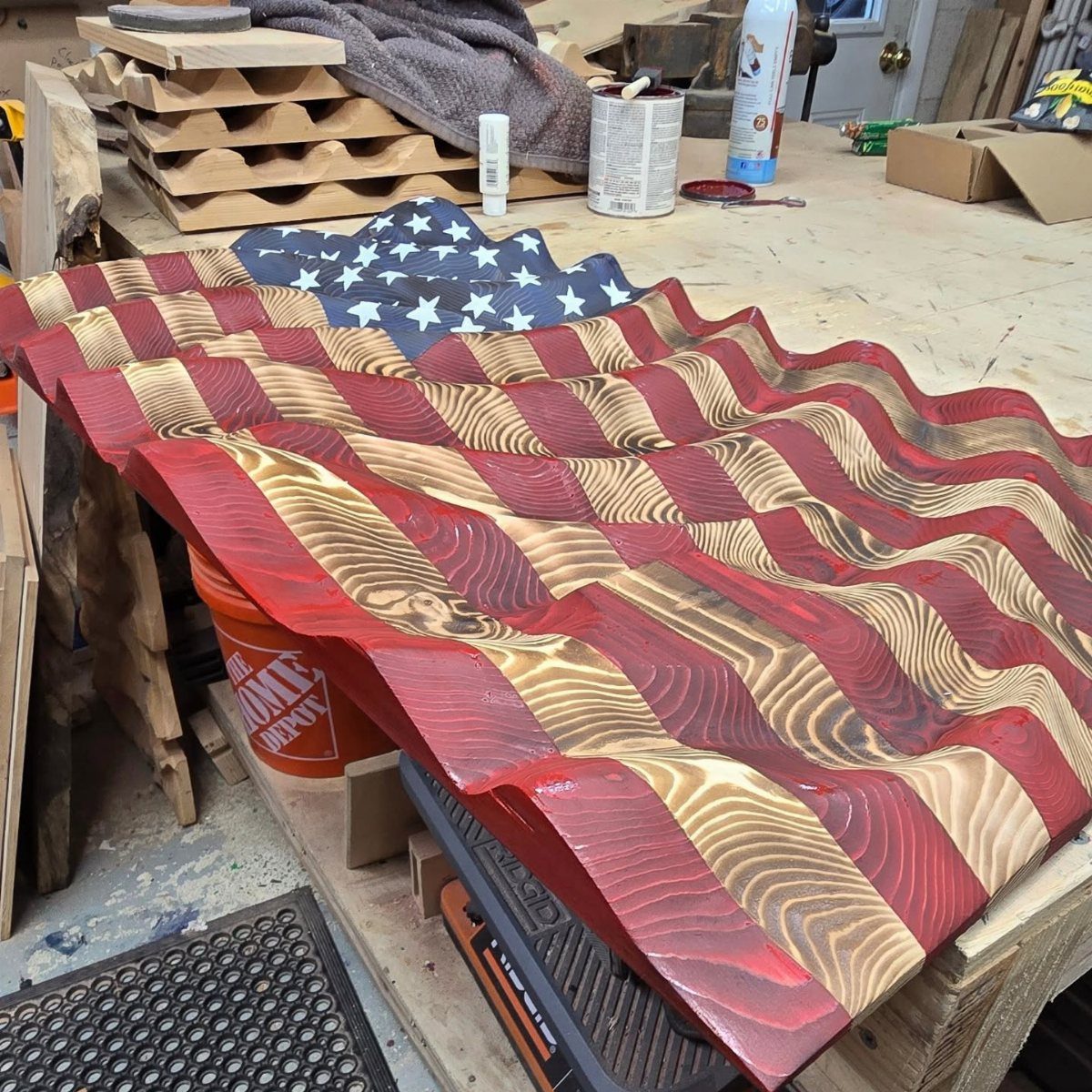 CNC Router Projects and Ideas: 10 Wood Pieces to Make 1 Carved wooden American flag with wavy 3D stripes resting on a workshop table.
