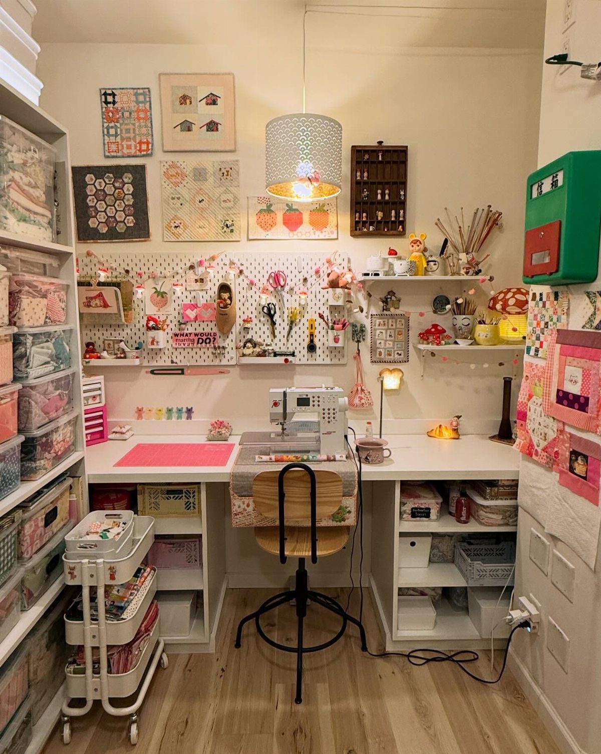 Organized craft room with sewing station, pegboard, rolling cart, and white storage shelving.