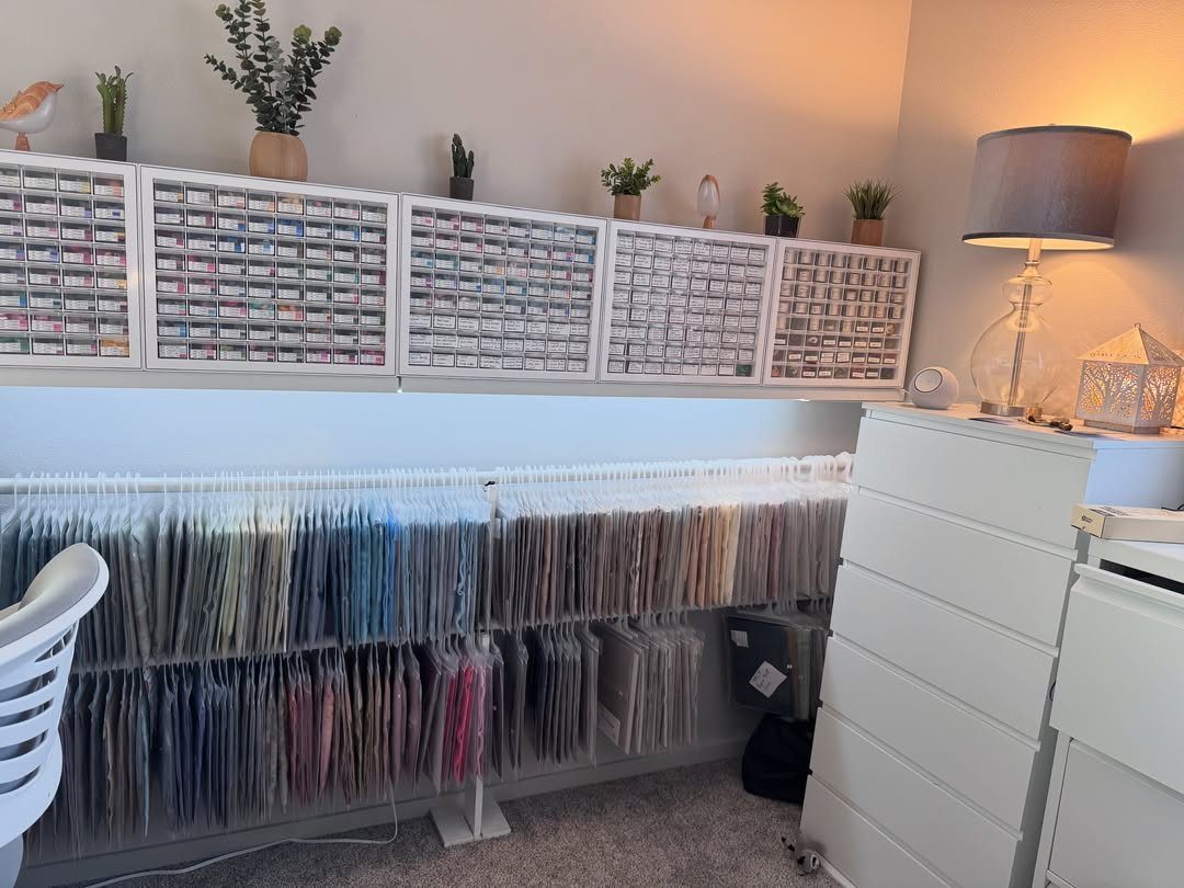 Fabric remnants organized in clear plastic sleeves within a white filing system.