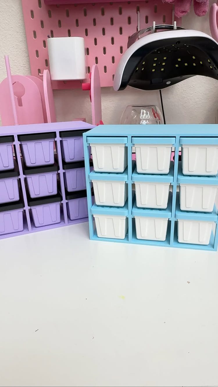 Purple and blue plastic tilt bin organizers on a white craft table.