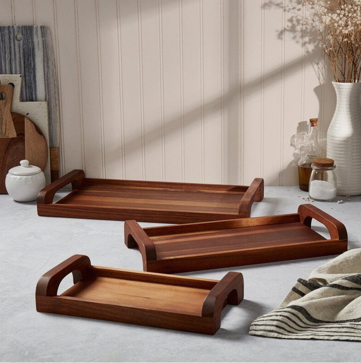 14 DIY Home Decor Wood Ideas for Every Room in the House 8 Three stained wooden trays with handles arranged on a light grey surface.