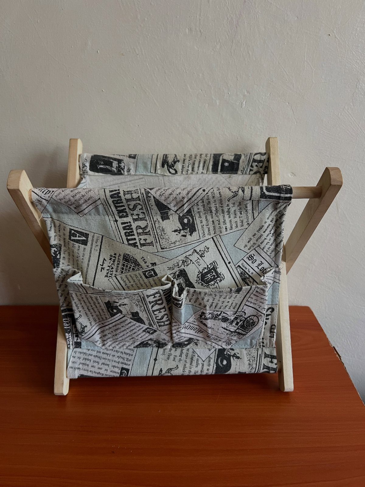 14 DIY Home Decor Wood Ideas for Every Room in the House 5 Fabric magazine organizer with newspaper print held by a light wooden frame.
