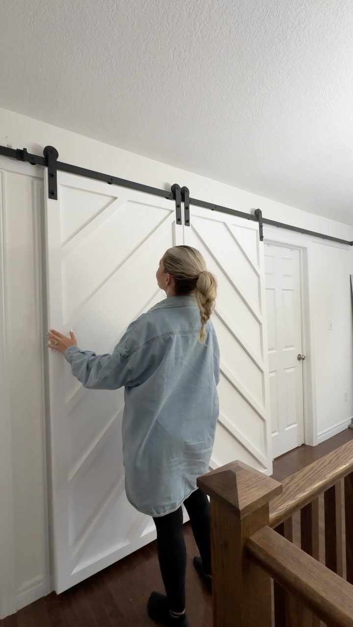 14 DIY Home Decor Wood Ideas for Every Room in the House 7 White wooden sliding barn door with diagonal planks on a black metal track.