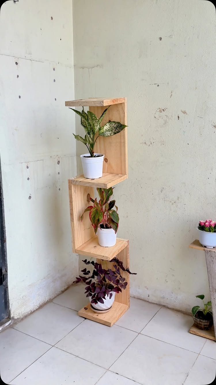 14 DIY Home Decor Wood Ideas for Every Room in the House 12 Wooden plant stand with three staggered shelves holding potted green plants.