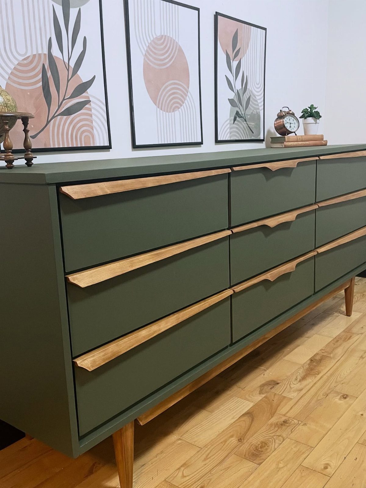 Olive green dresser with natural wood accents and abstract art on the wall