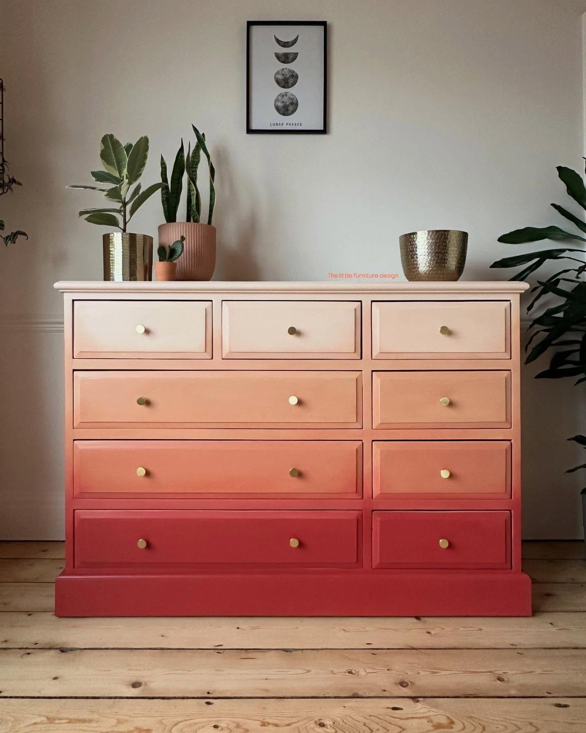 Ombre painted dresser with drawers transitioning from cream to deep red with gold knobs.