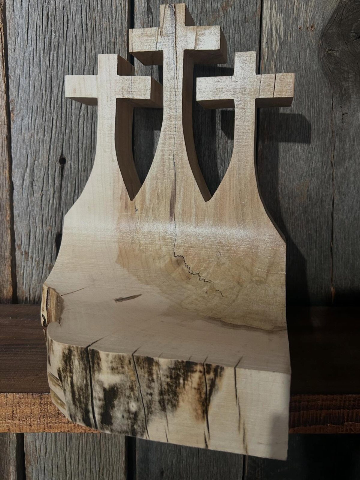 DIY Wooden Crosses: 5 Ideas, from Woven to Carved 5 Three wooden crosses carved from a single block of light-colored wood.