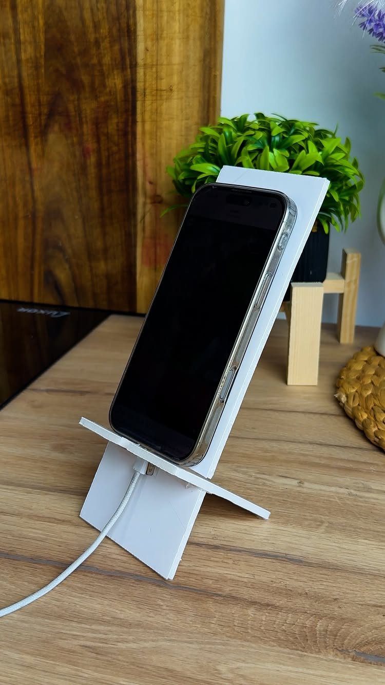 14 Easy Things to Make Out of Wood for Beginners 1 White wooden phone stand holding a smartphone on a wooden desk surface.