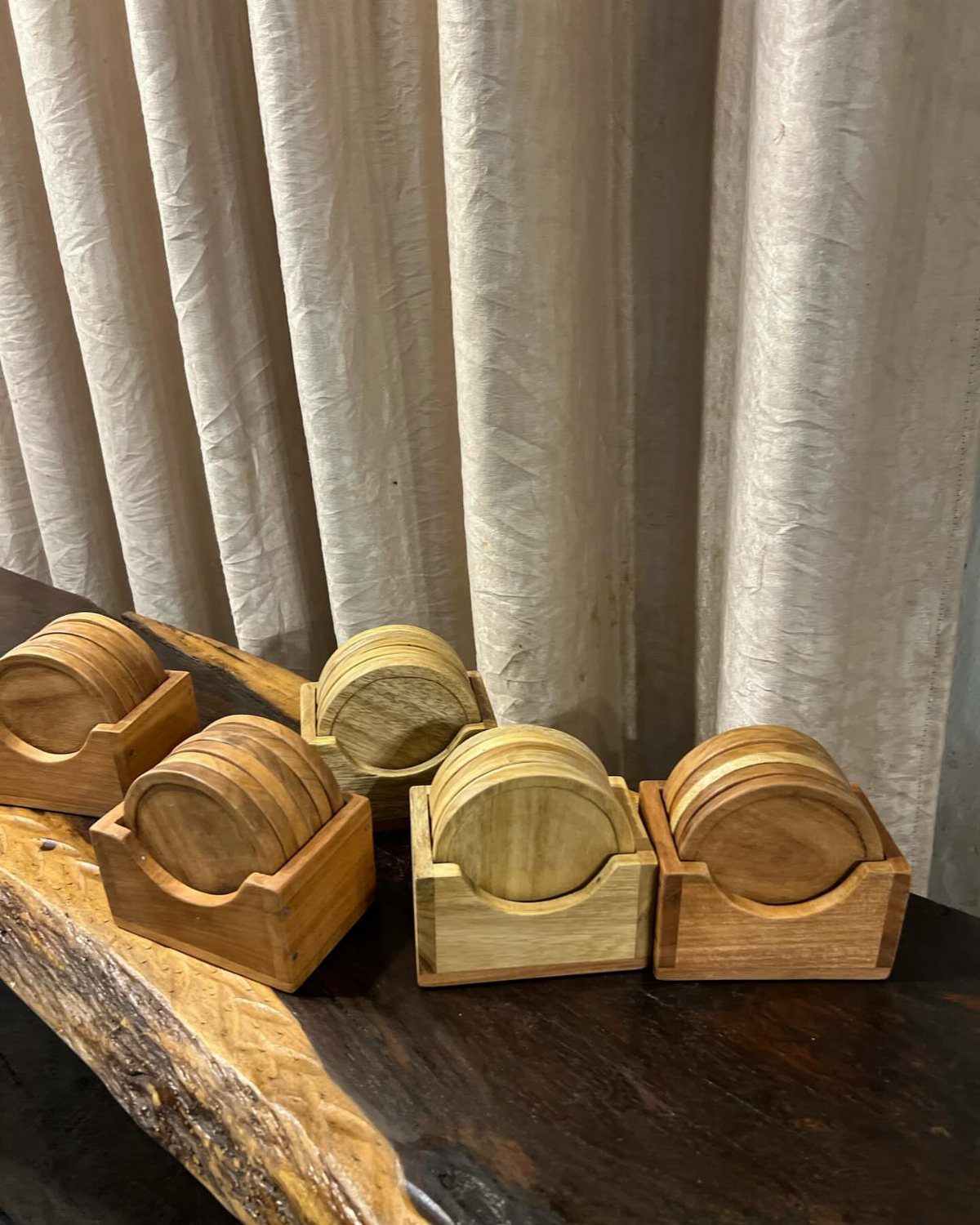 14 Easy Things to Make Out of Wood for Beginners 2 Circular wooden coasters in square wooden holders on a dark live-edge table.