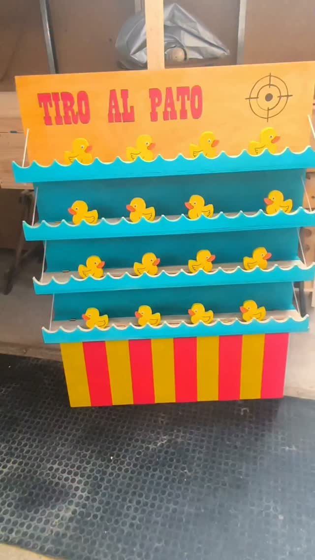 14 Easy Things to Make Out of Wood for Beginners 14 Wooden carnival game board with yellow ducks on blue shelves and striped base