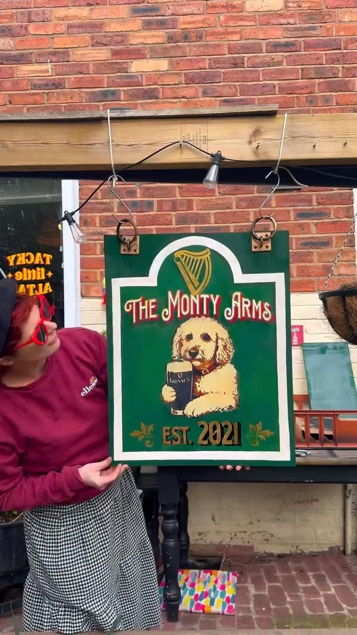 14 Easy Things to Make Out of Wood for Beginners 5 Green wooden pub sign featuring a dog and text hanging on a brick wall.