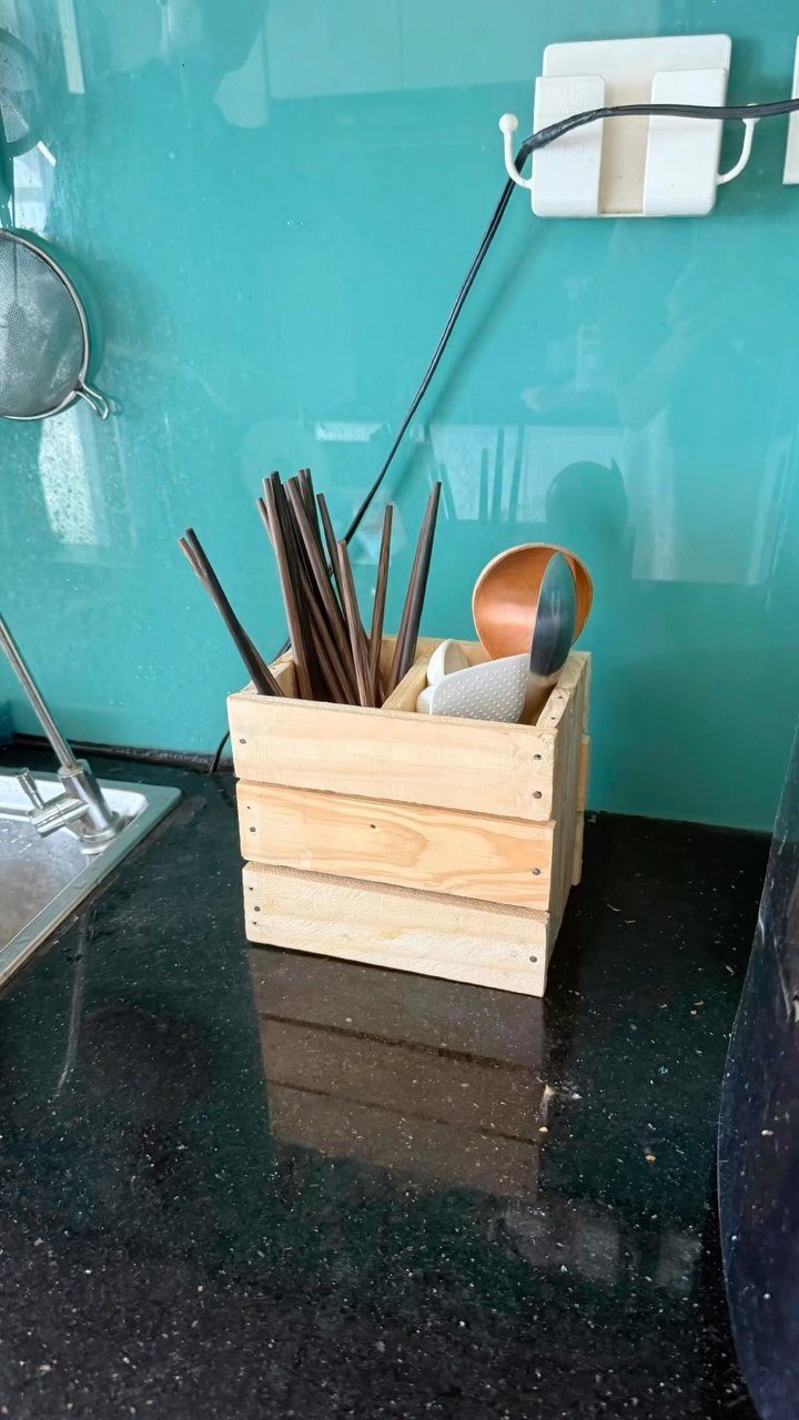 14 Easy Things to Make Out of Wood for Beginners 13 Wooden utensil holder containing chopsticks and a ladle on a black kitchen counter.