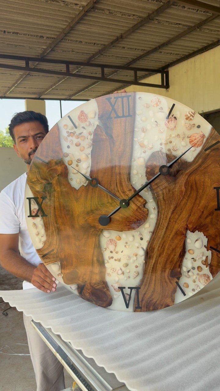 9 Epoxy Resin Wood Projects: Tables, Trays, Clocks and Coasters 3 Circular wall clock made from brown wood and white epoxy resin with seashells.
