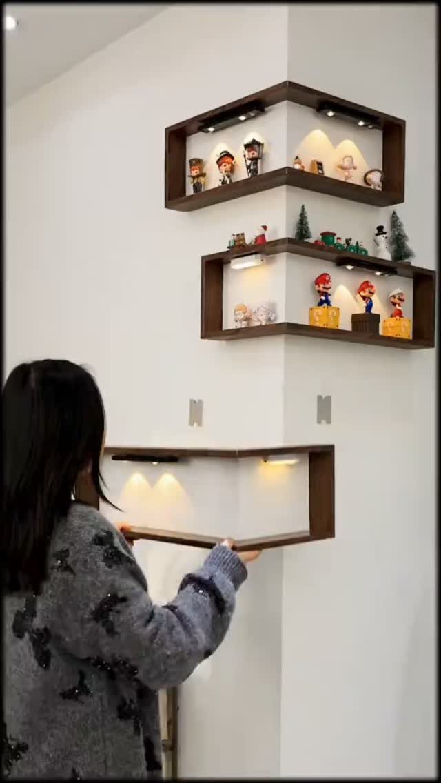 Dark brown wooden corner floating shelves arranged asymmetrically on a white wall.