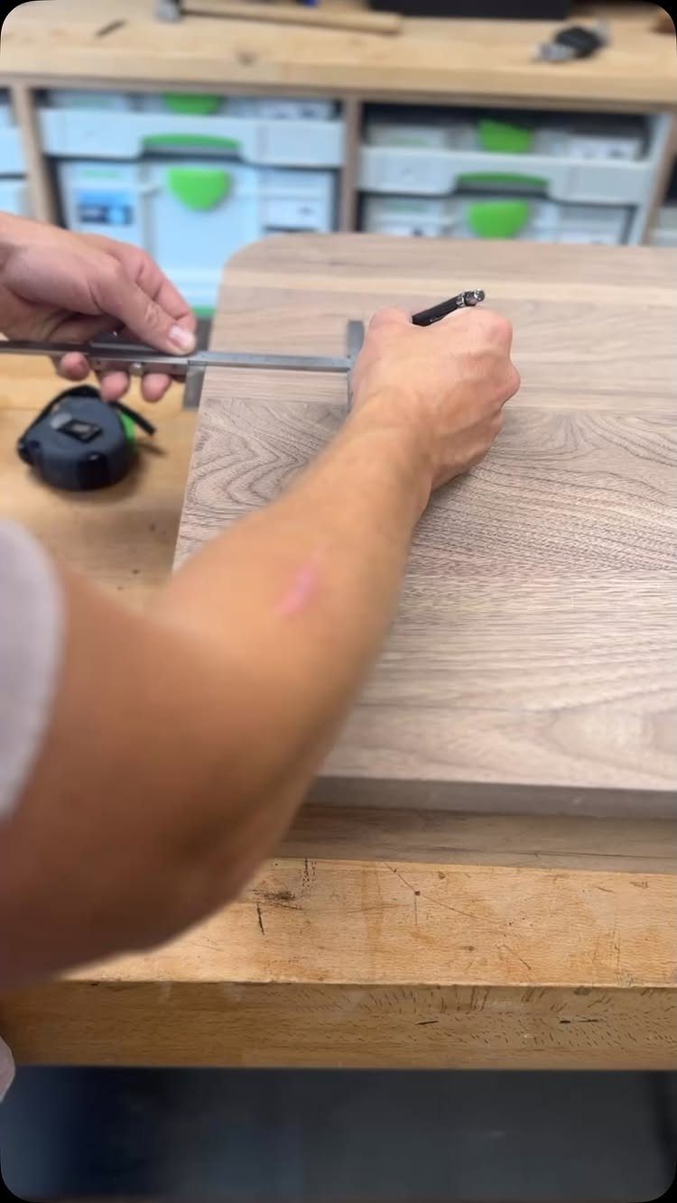 Furniture Making Tools: 11 Hand and Power Tools to Own 1 Hands using a combination square and pencil to mark a wooden board on a workbench.