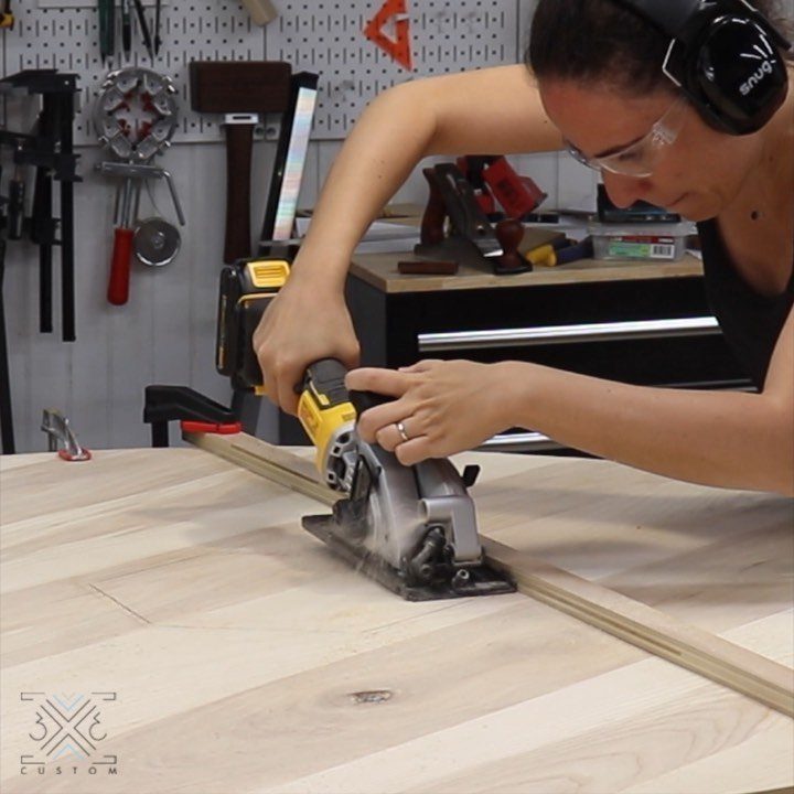 Furniture Making Tools: 11 Hand and Power Tools to Own 8 Woman using a power jigsaw to cut a light wooden board in a workshop.