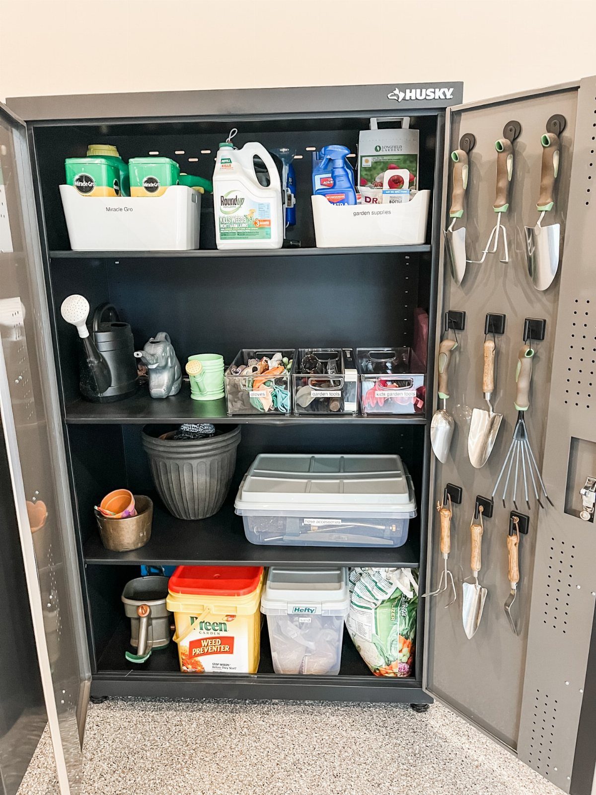 10 Garden Tool Storage Ideas for Any Yard or Garage 8 Grey metal storage cabinet with gardening tools hanging on the door and supplies on shelves.