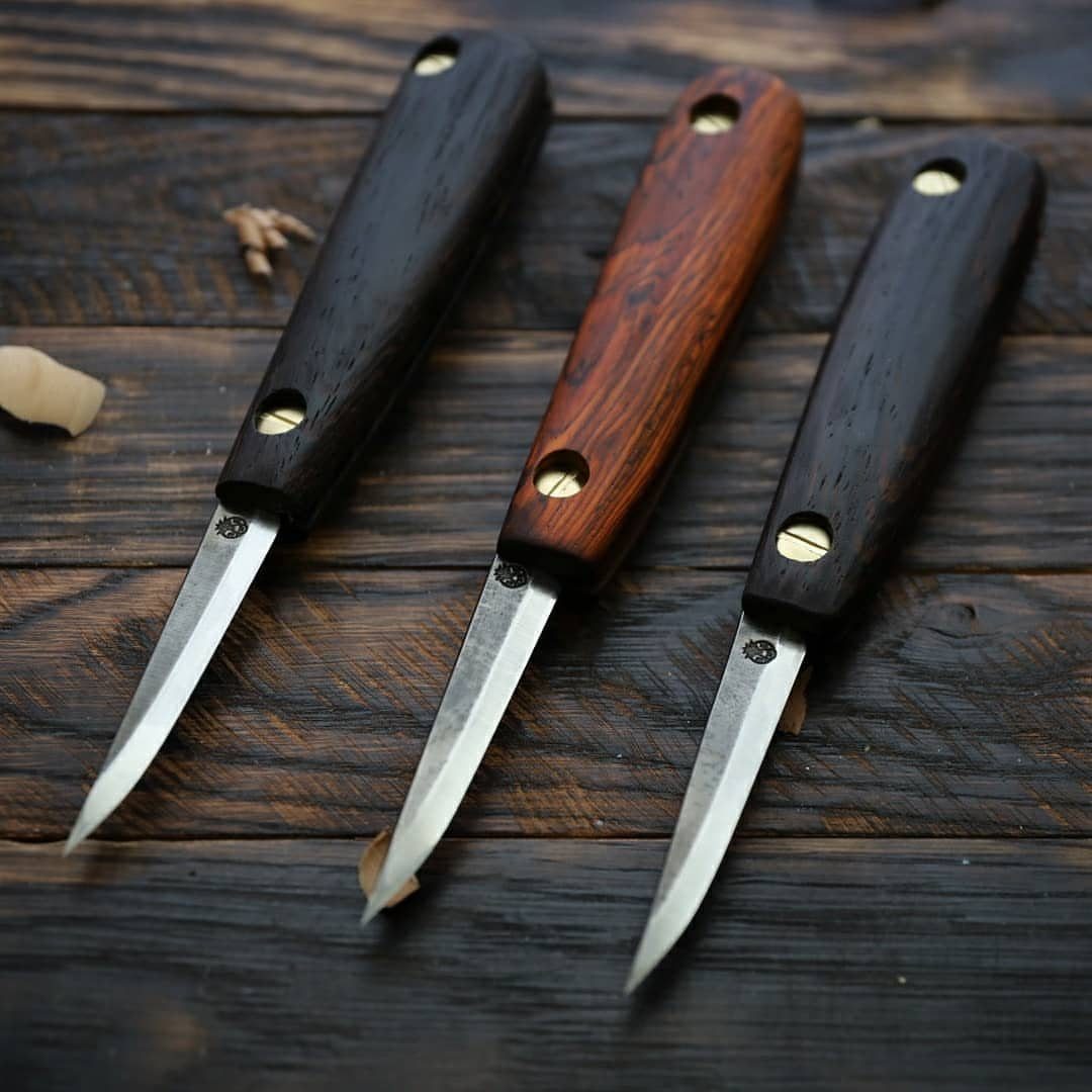 Green Woodworking Tools: 6 Essentials for the Workshop 6 Three carving knives with wooden handles lying on a dark wooden surface.