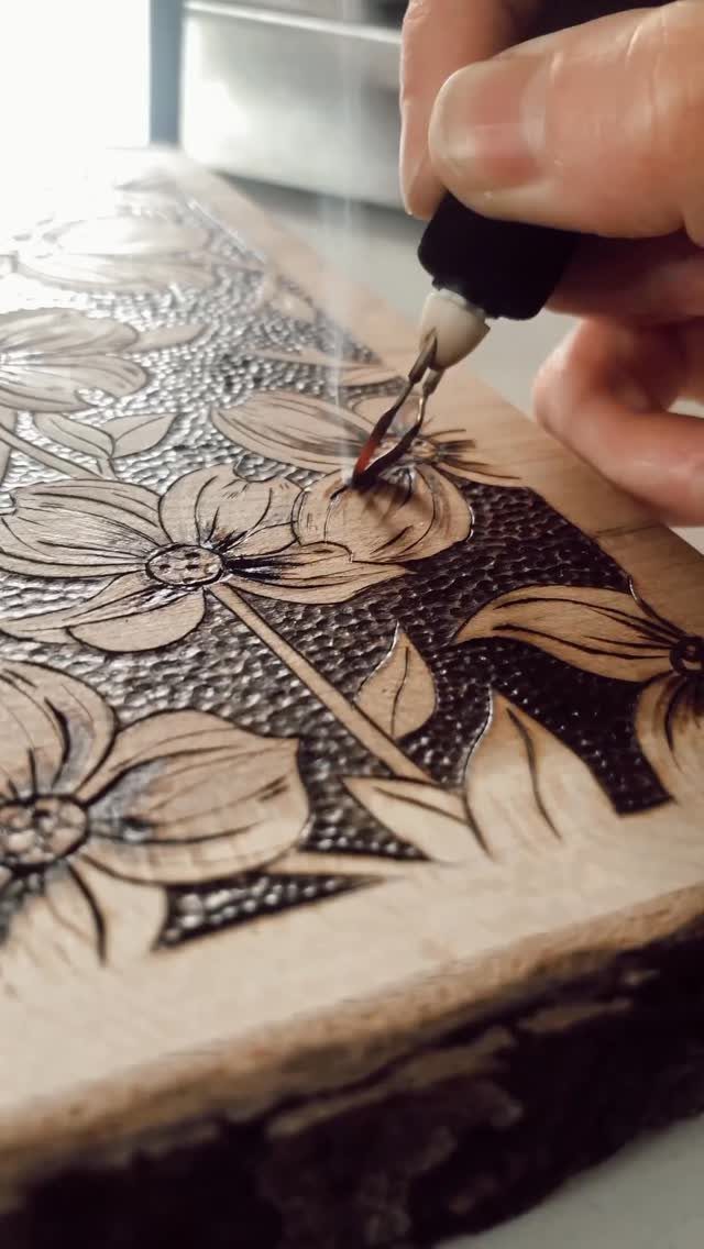 How to Burn Wood Art: 12 Ideas for Every Skill Level 10 Hand using a pyrography tool to burn floral art into a wooden slab.