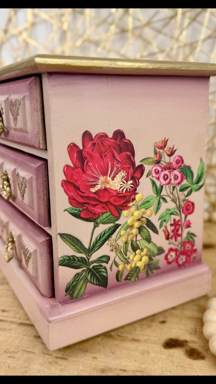 Pink wooden jewelry box with three drawers and a painted red floral design.
