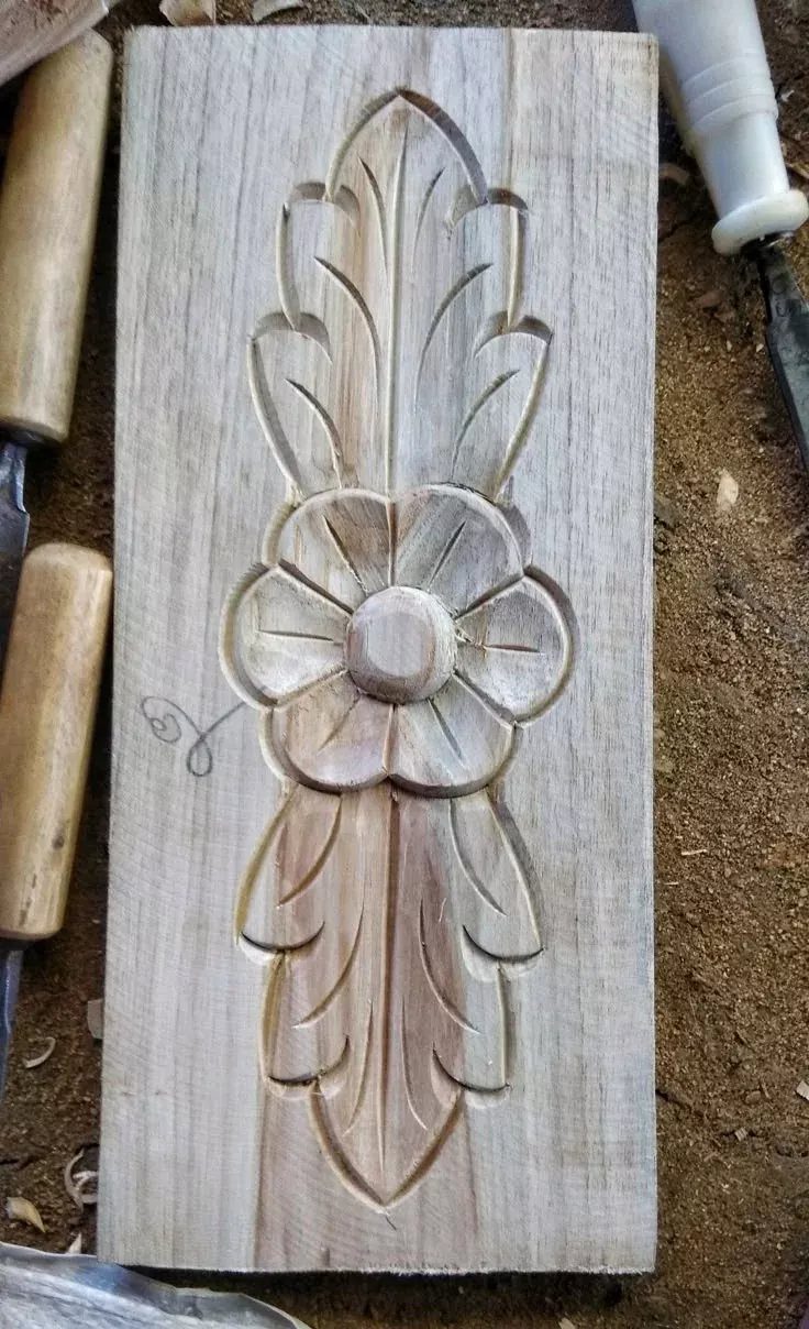 Learn How to Carve Wood: 4 Ideas to Start With 1 Carved floral relief design on a flat piece of light-colored wood with tools.