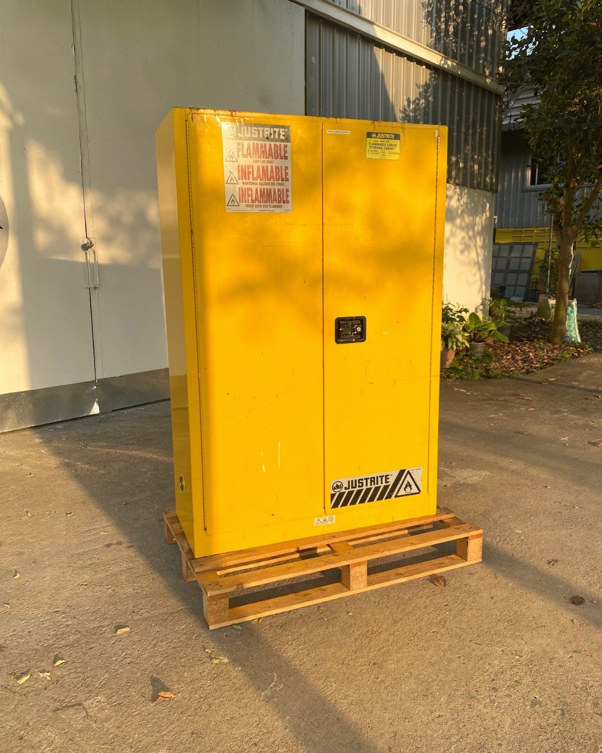 Paint Storage Cabinet Ideas: 6 Options for Art and Workshop 6 Yellow metal flammable liquid storage cabinet sitting on a wooden pallet outdoors.