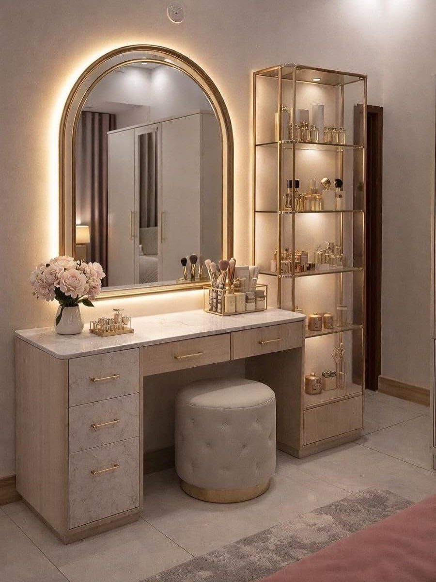 Modern dresser vanity with marble top, arched backlit mirror, and gold shelving unit.