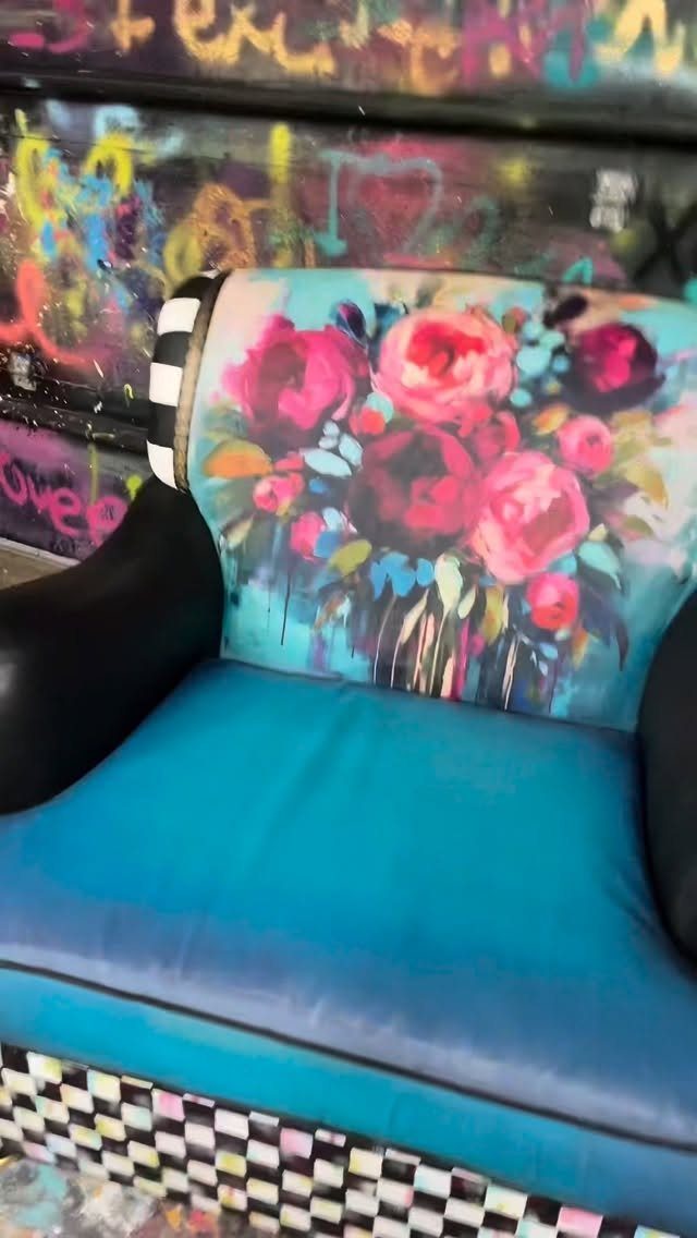 Blue armchair with painted pink flowers on the backrest and checkered base.