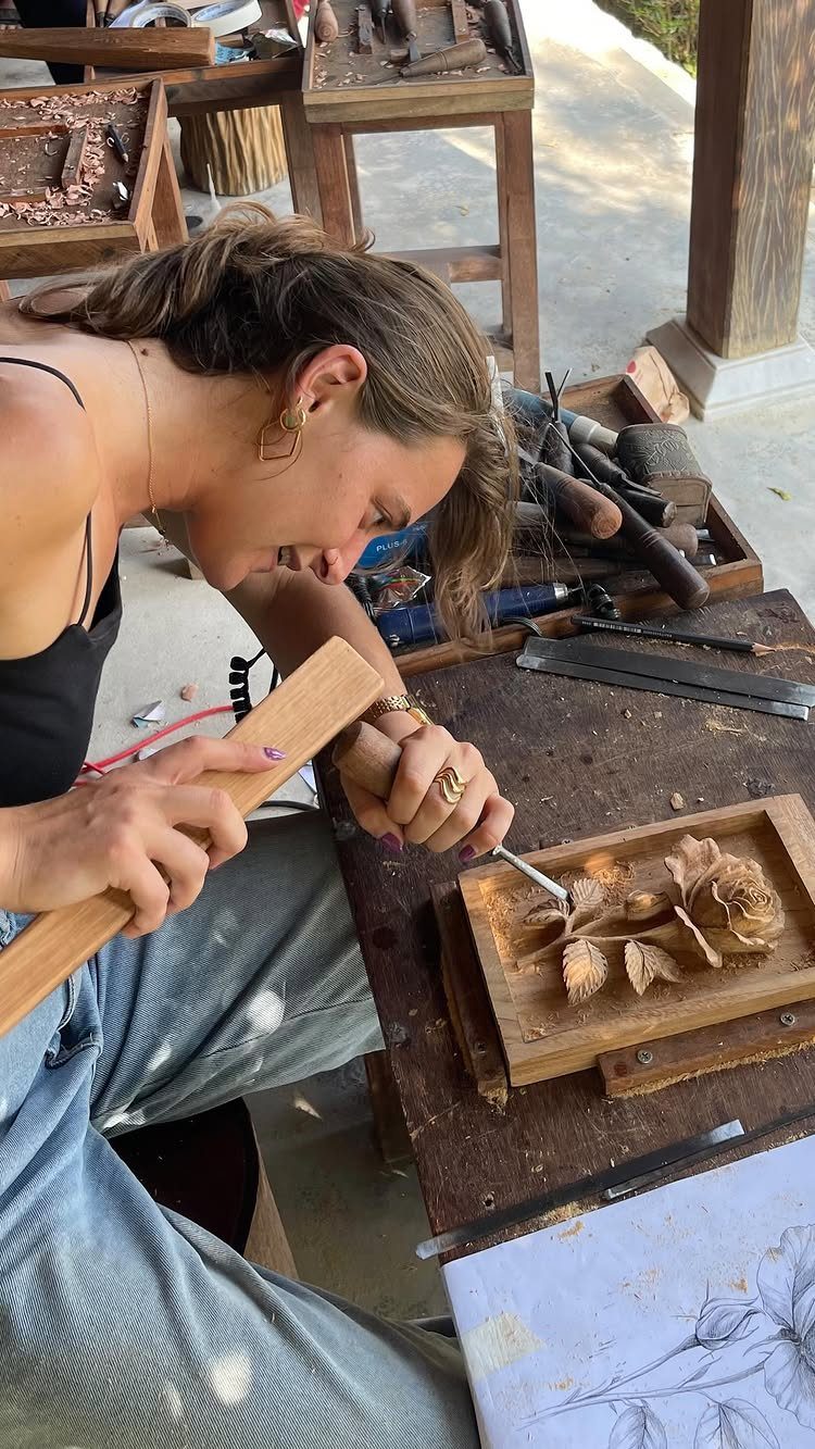Relief Wood Carving Ideas: 5 Projects to Try at Home 5 Woman carving a floral relief design into a wooden block with a mallet.
