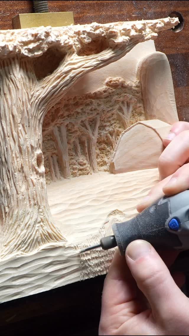 Relief Wood Carving Ideas: 5 Projects to Try at Home 4 Hand using a rotary tool to carve a detailed forest scene in wood.