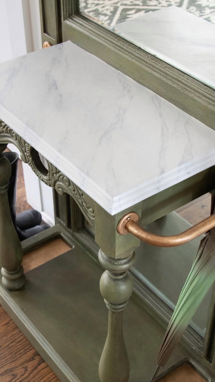 Olive green furniture with a white faux marble painted top and copper handle.