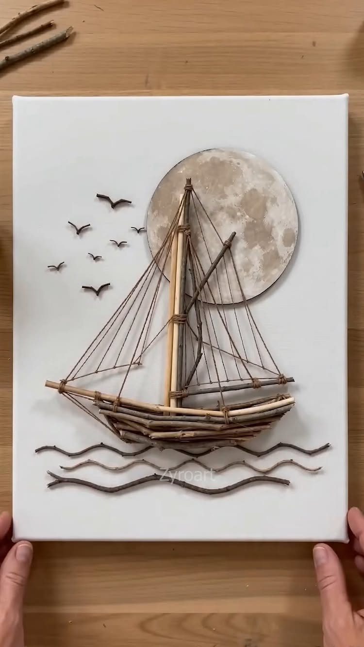 Sailboat made of wooden twigs and string on a white canvas with a moon.
