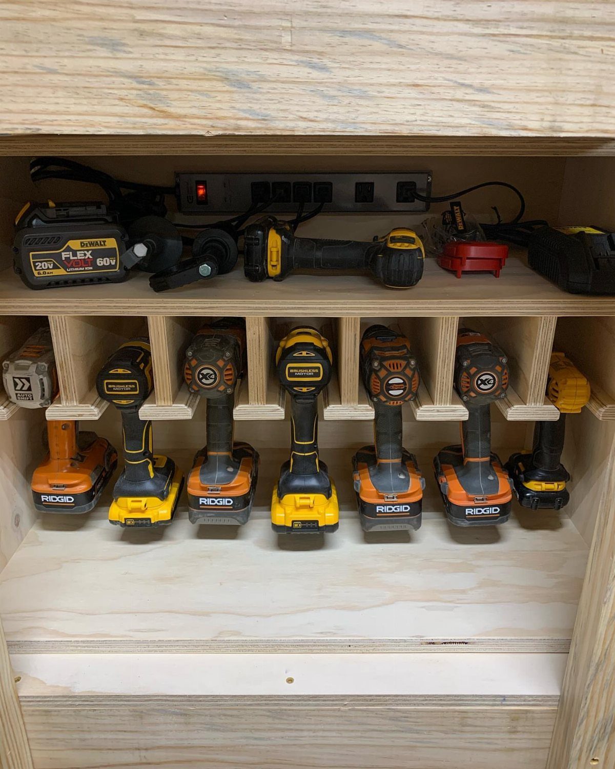 14 Shop Class Projects to Build: Bookshelf to Plywood Cart 8 Wooden cordless drill charging center holding multiple power drills and batteries in a workshop.