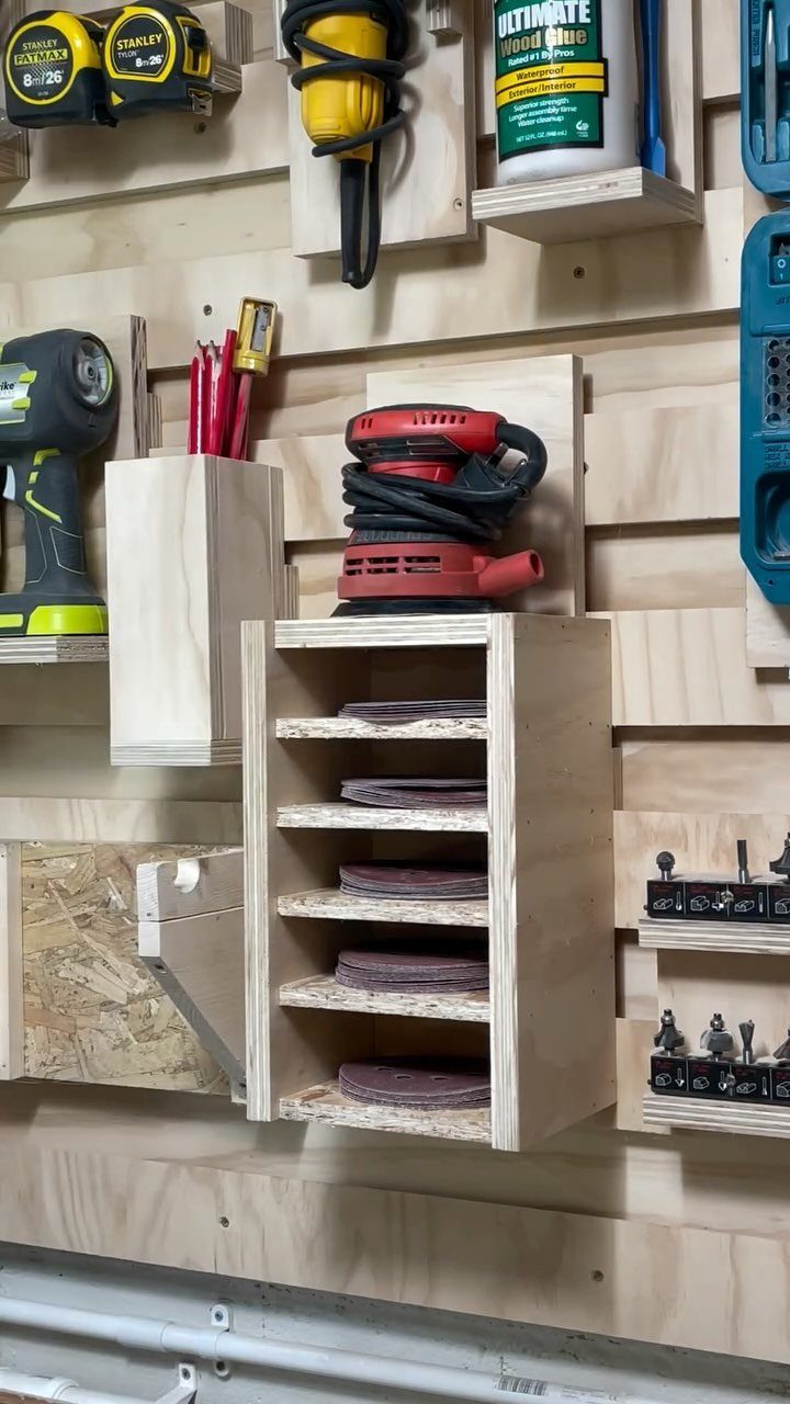 14 Shop Class Projects to Build: Bookshelf to Plywood Cart 9 Wooden sandpaper disc storage rack mounted on a workshop wall with various tools.