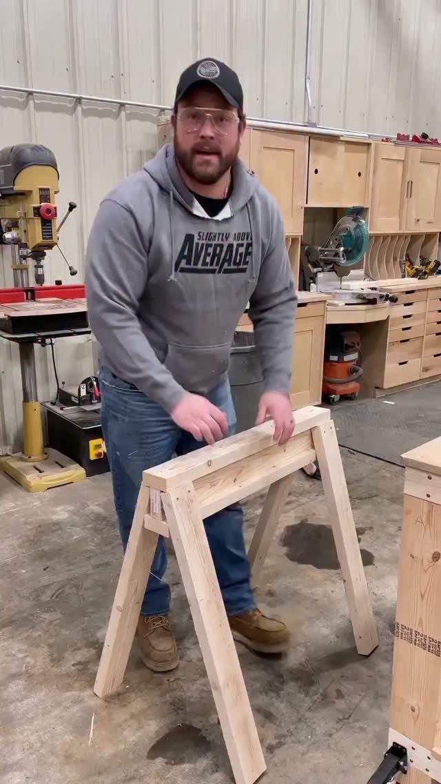 14 Shop Class Projects to Build: Bookshelf to Plywood Cart 10 Man in a workshop holding a small unfinished wooden A-frame project.