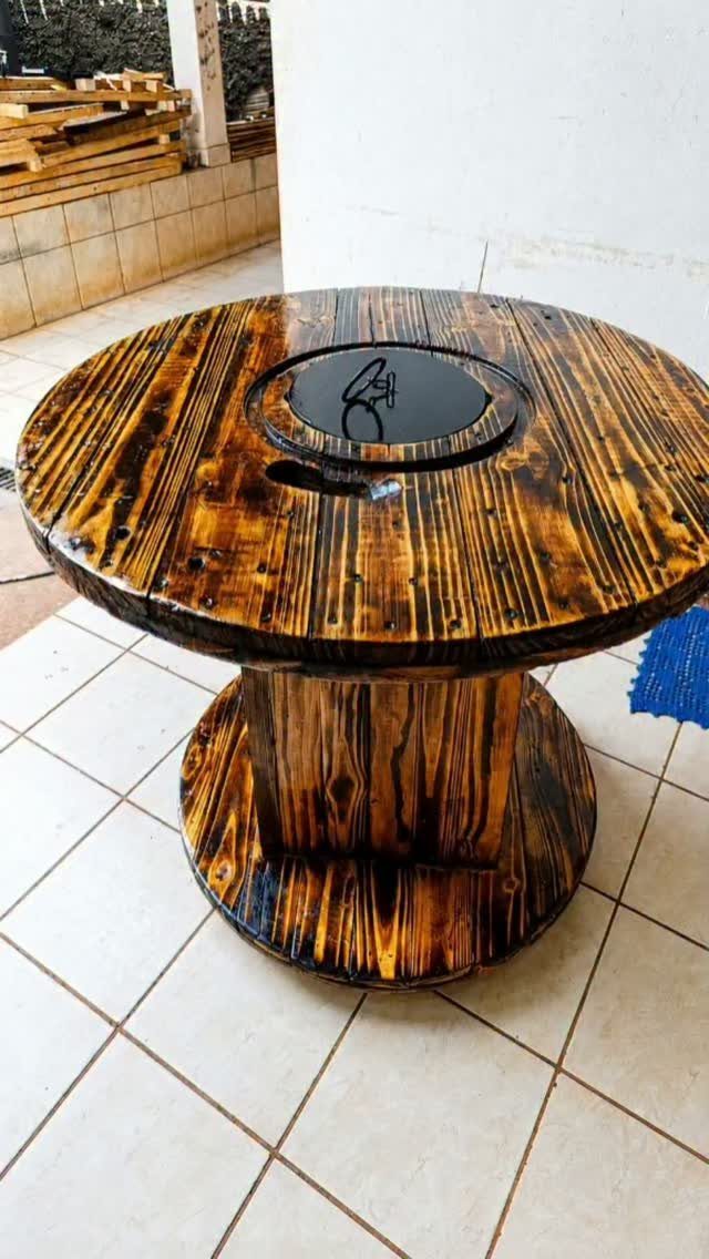 Round wooden table with charred black grain and golden-brown color stain finish.