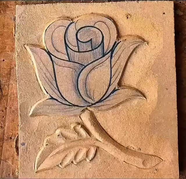 Carved wooden rose with a stem and leaf on a square block