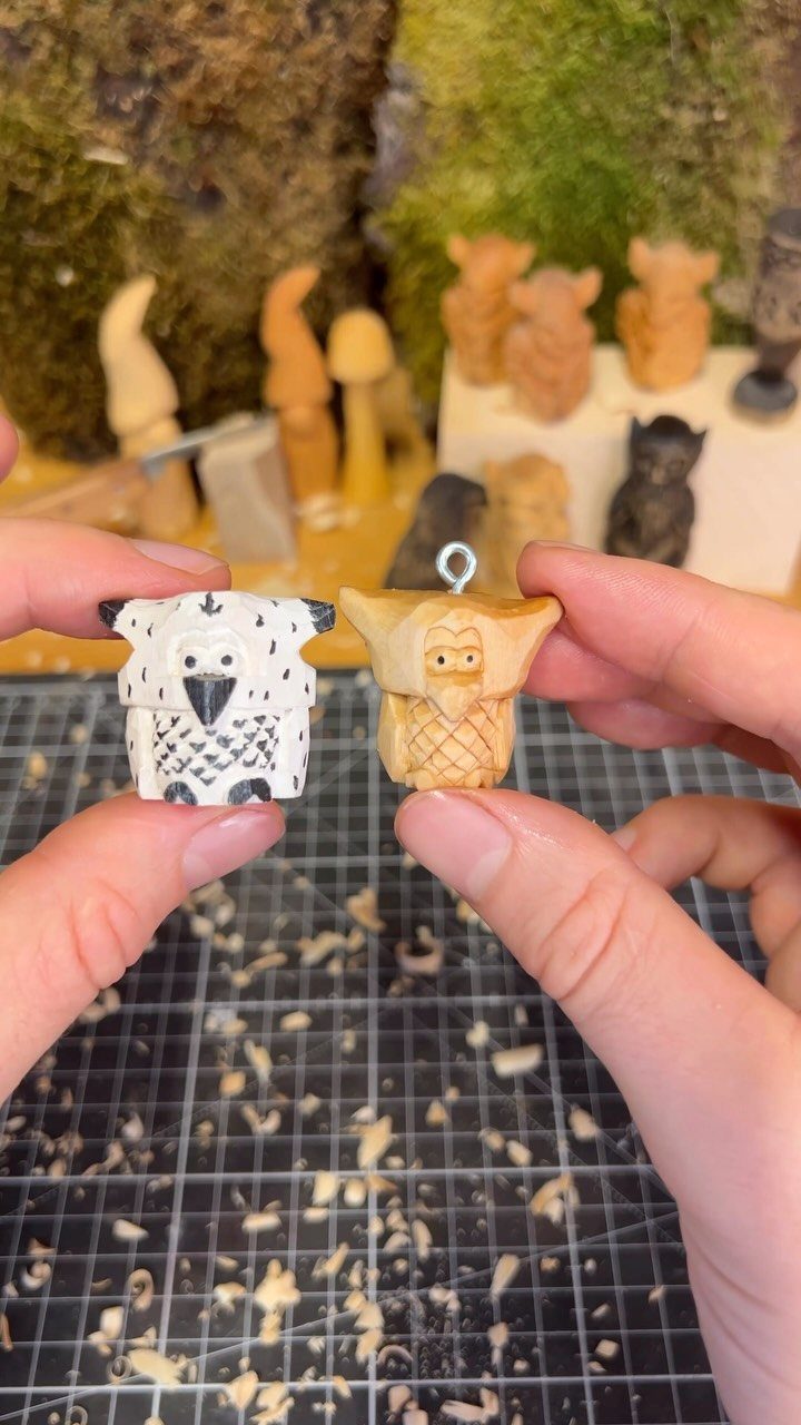 Two small hand-carved wooden animal figurines held over a mat with wood shavings.