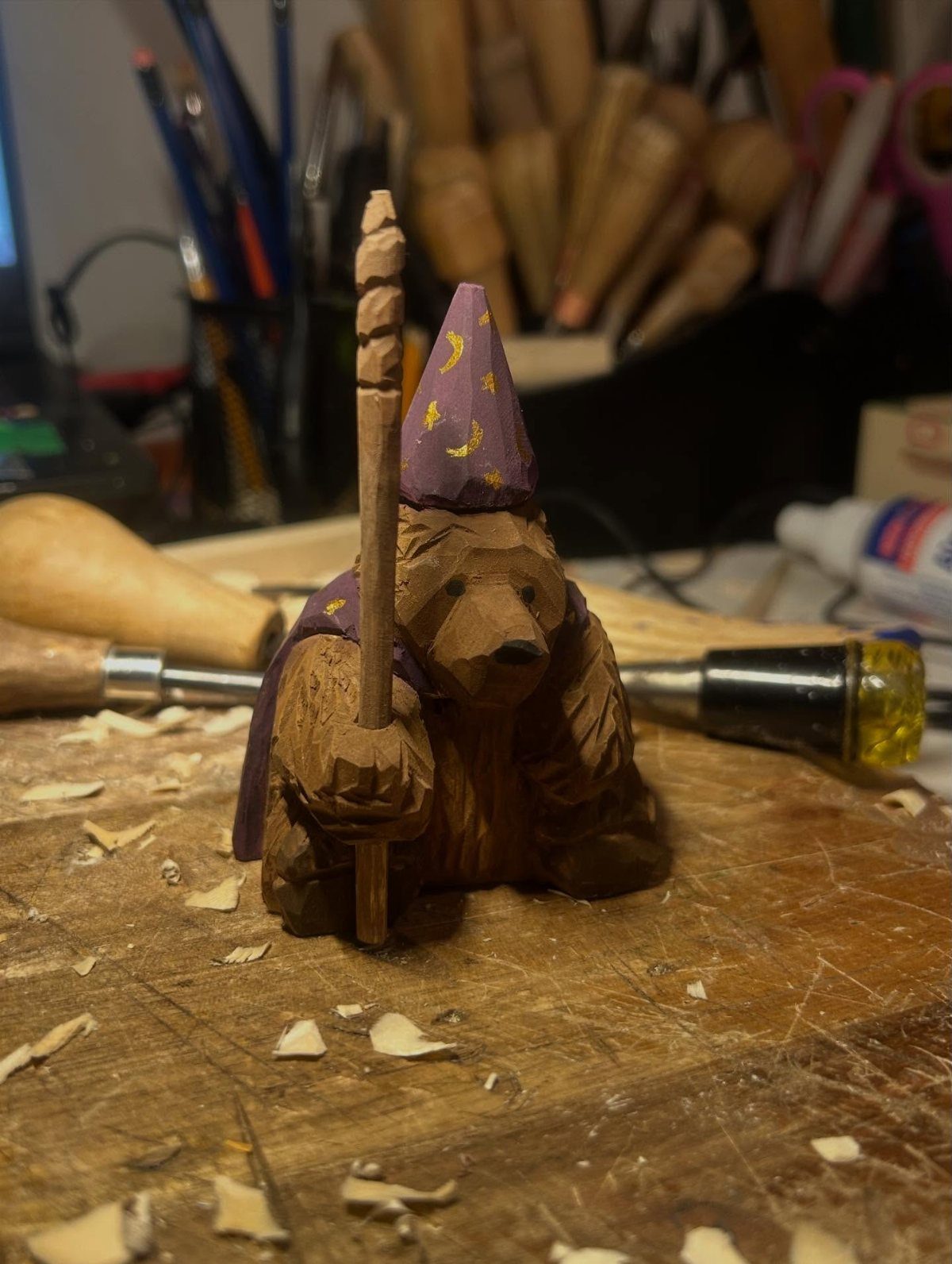 Small wooden bear carving dressed as a wizard with a hat and staff