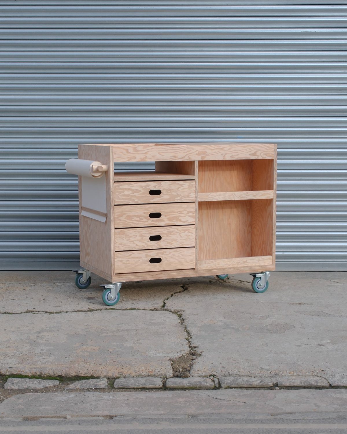 12 Small Wood Projects for Beginners to Build This Weekend 4 Wooden utility cart with drawers and caster wheels against a grey metal wall.