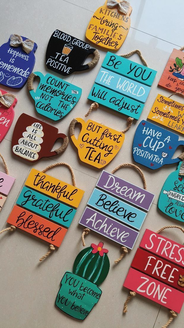 Colorful painted wooden plaques with inspirational quotes in various shapes and bright colors.