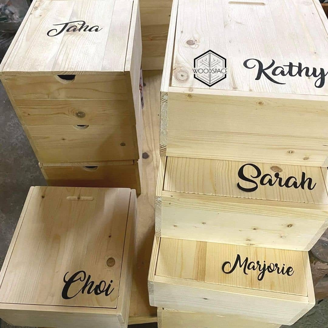 Wooden boxes with personalized names written in black cursive script on the lids.