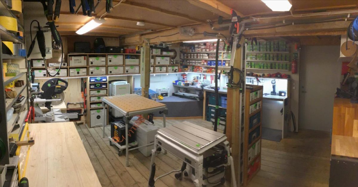 Small woodshop with organized functional areas including a table saw and miter saw.